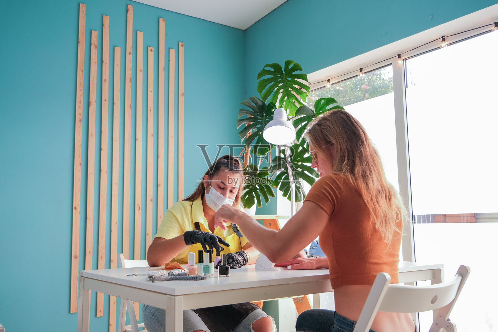 美甲大师在美容院为顾客做美甲修甲照片摄影图片