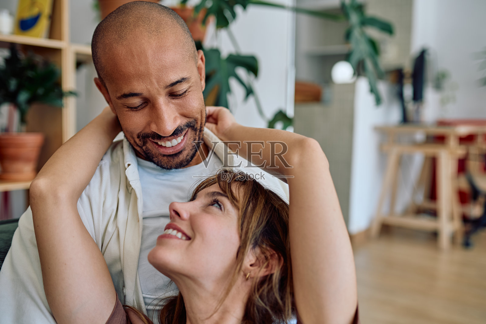 一对幸福的情侣在家中相拥而笑。照片摄影图片