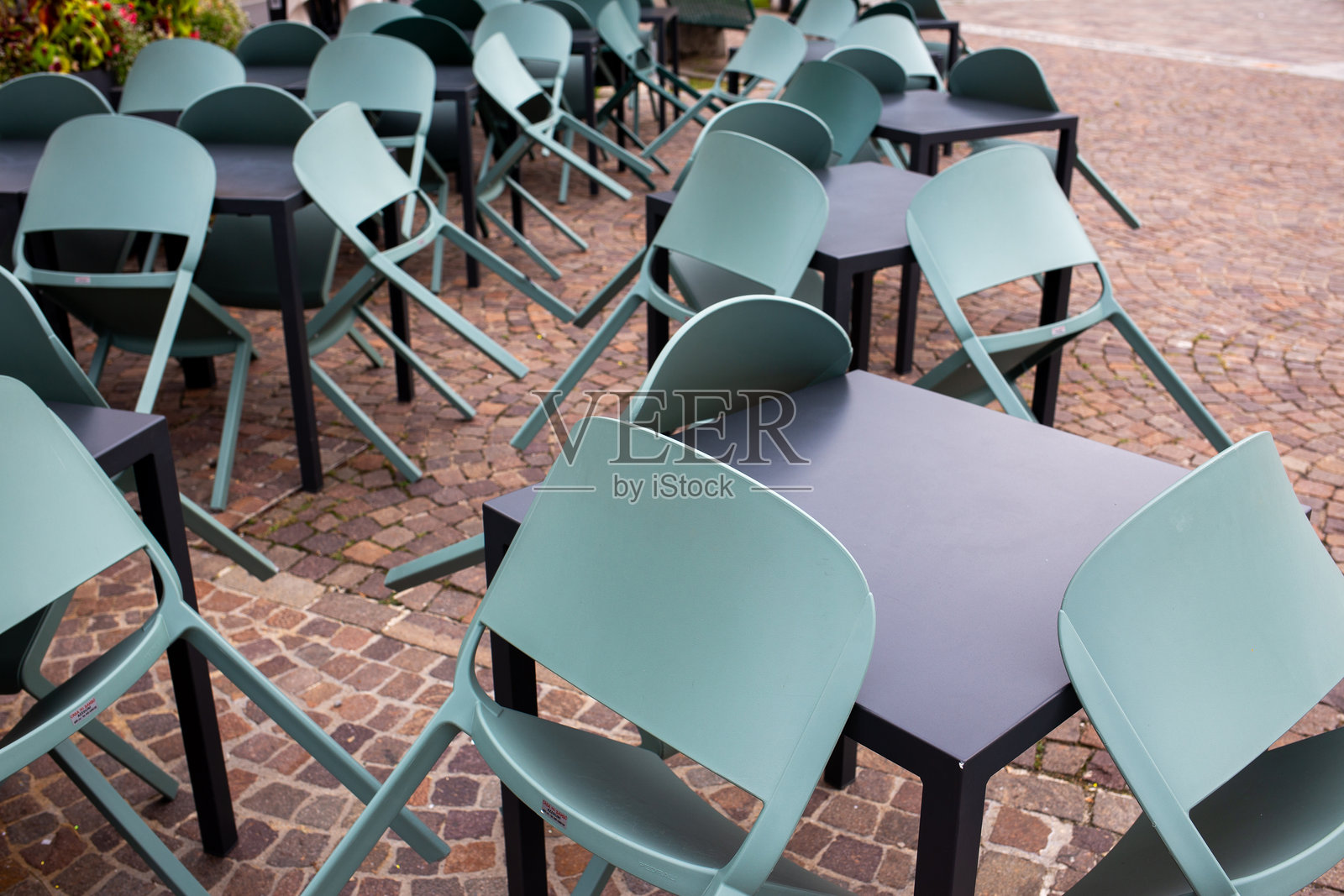 石板路上堆叠的户外椅子和桌子照片摄影图片