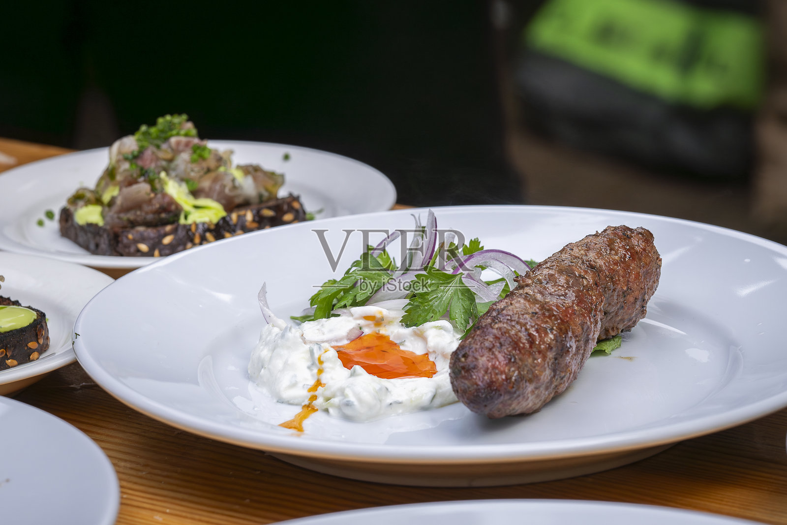 传统的自制羊肉肉饼或肉串,配有酱汁和酸奶。照片摄影图片