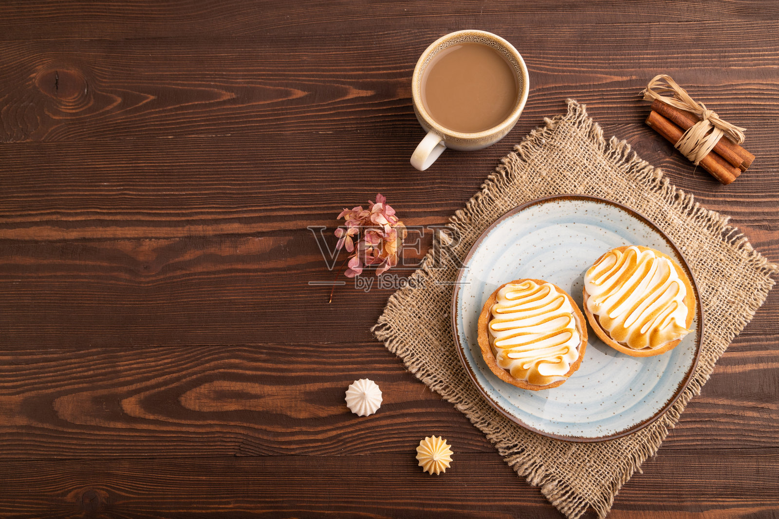 法式柠檬挞配蛋白霜,俯视角度,平铺,留有复制空间,背景为棕色木质和亚麻织物。照片摄影图片