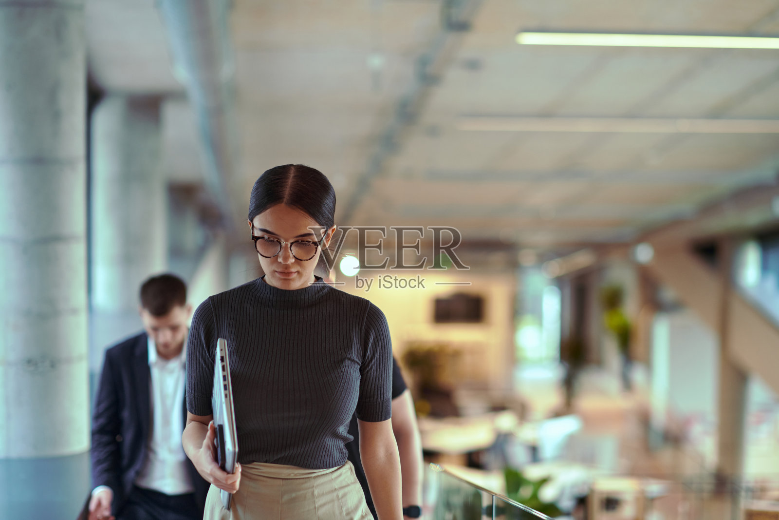 在现代企业环境中,一群来自不同背景和文化的多元化商务人士,正穿梭于一家前沿创业公司的走廊中,步伐矫健,充分展现了协作、抱负以及职场的活力。照片摄影图片