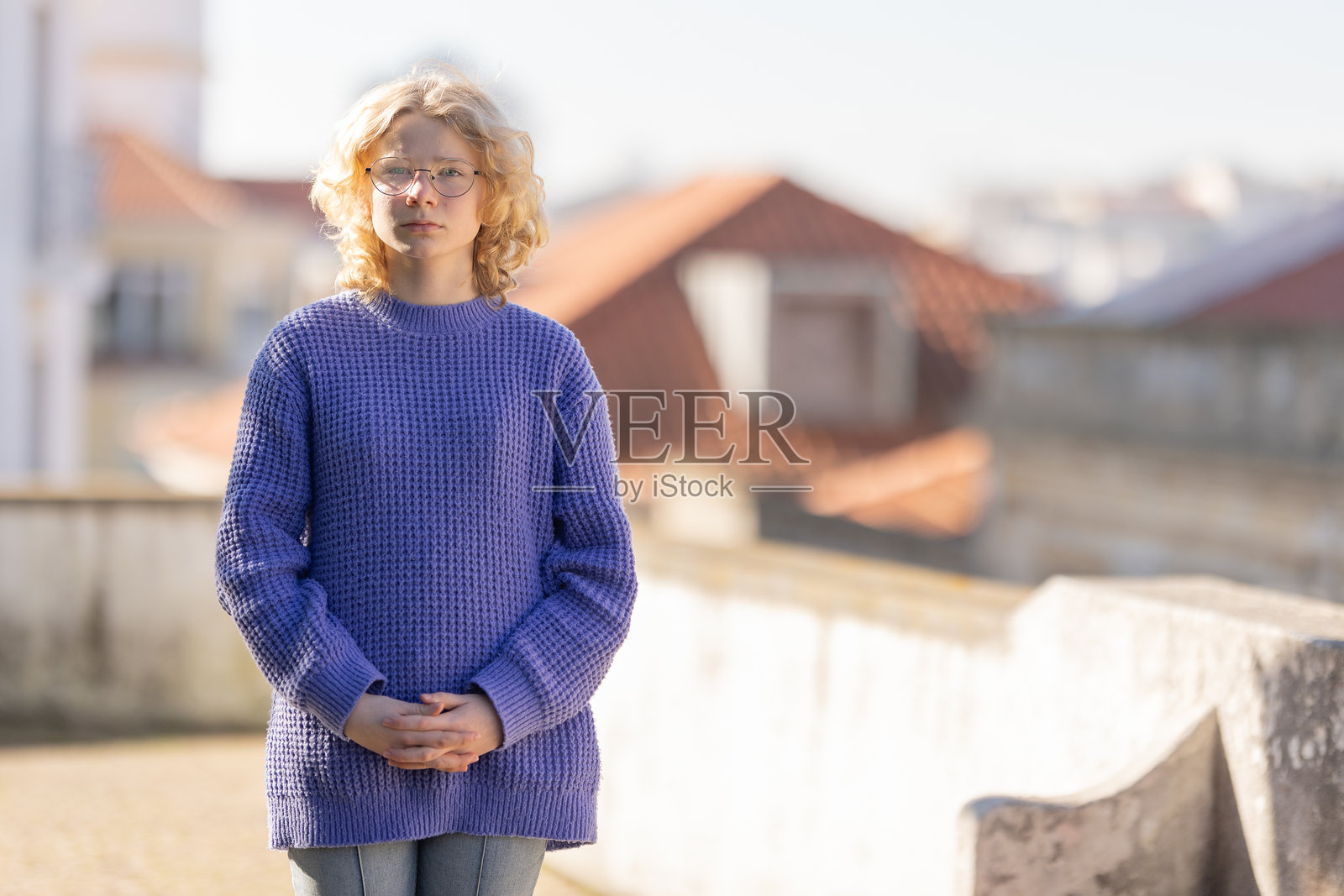 戴眼镜的年轻女子站在屋顶上照片摄影图片
