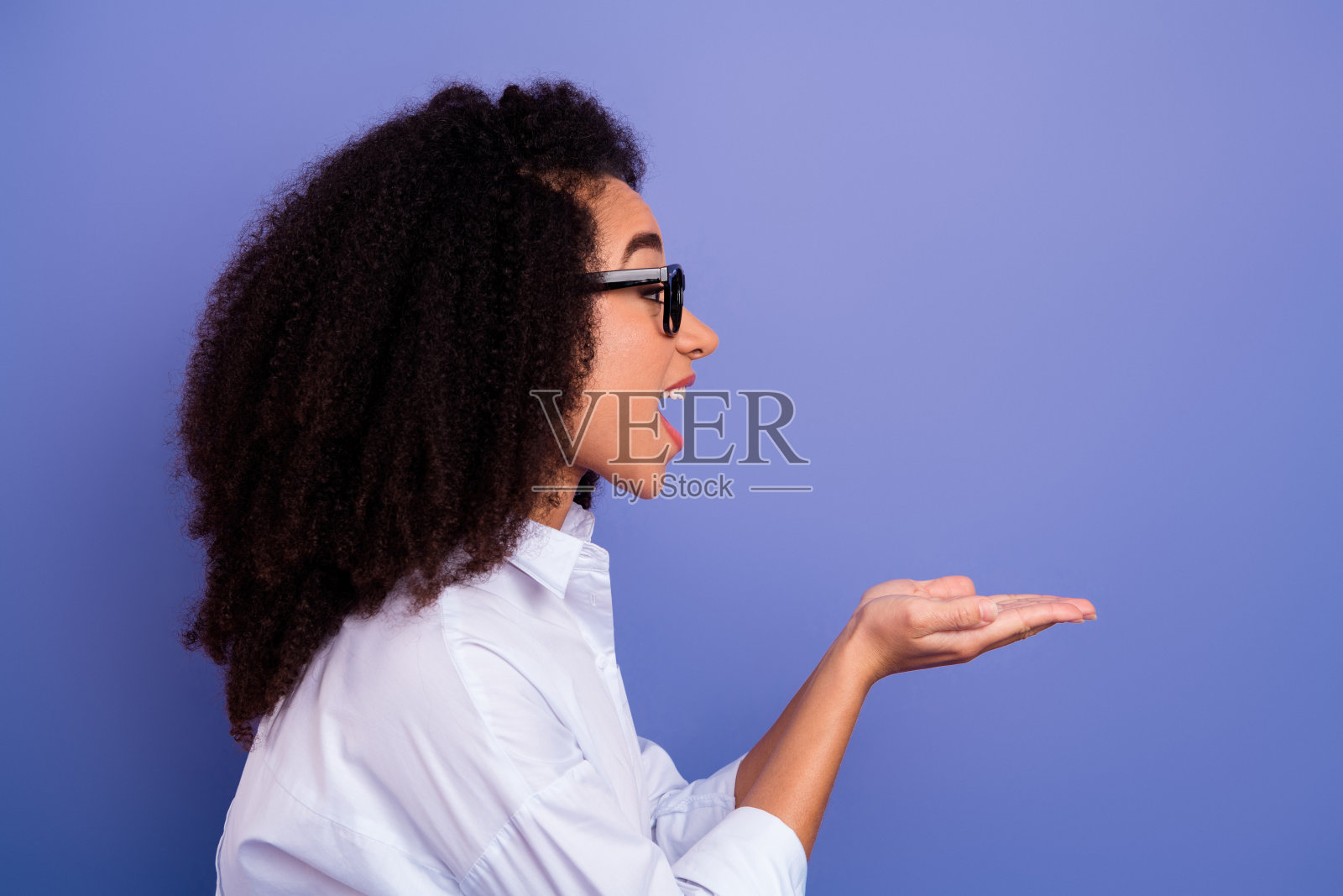 一位面带微笑、表情丰富、造型时尚的年轻女子,背景是充满活力的紫色,画面简洁。照片摄影图片