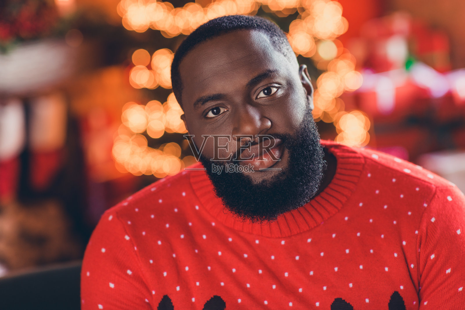 年轻帅气的非洲裔男子在室内开心地带着积极的笑容,充满节日庆典的圣诞时光氛围照片摄影图片