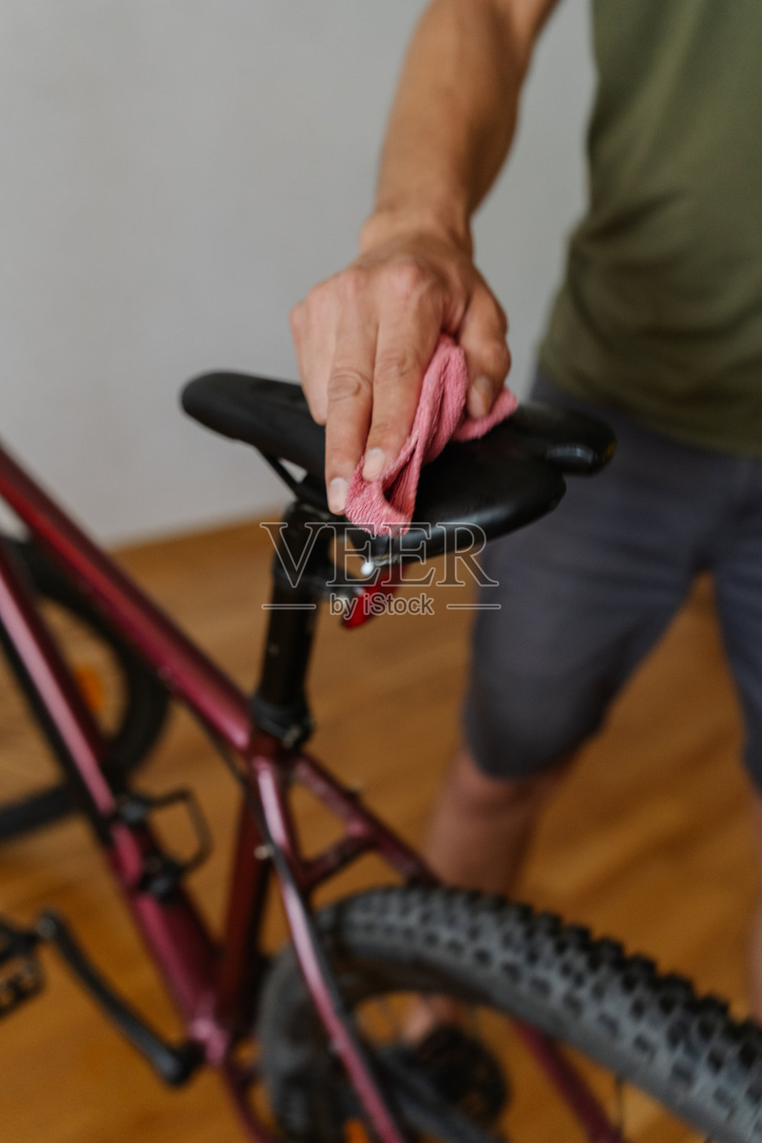 垂直裁剪的骑行者用超细纤维布清洁自行车鞍座的镜头,在越野骑行后进行详细保养,特写。照片摄影图片