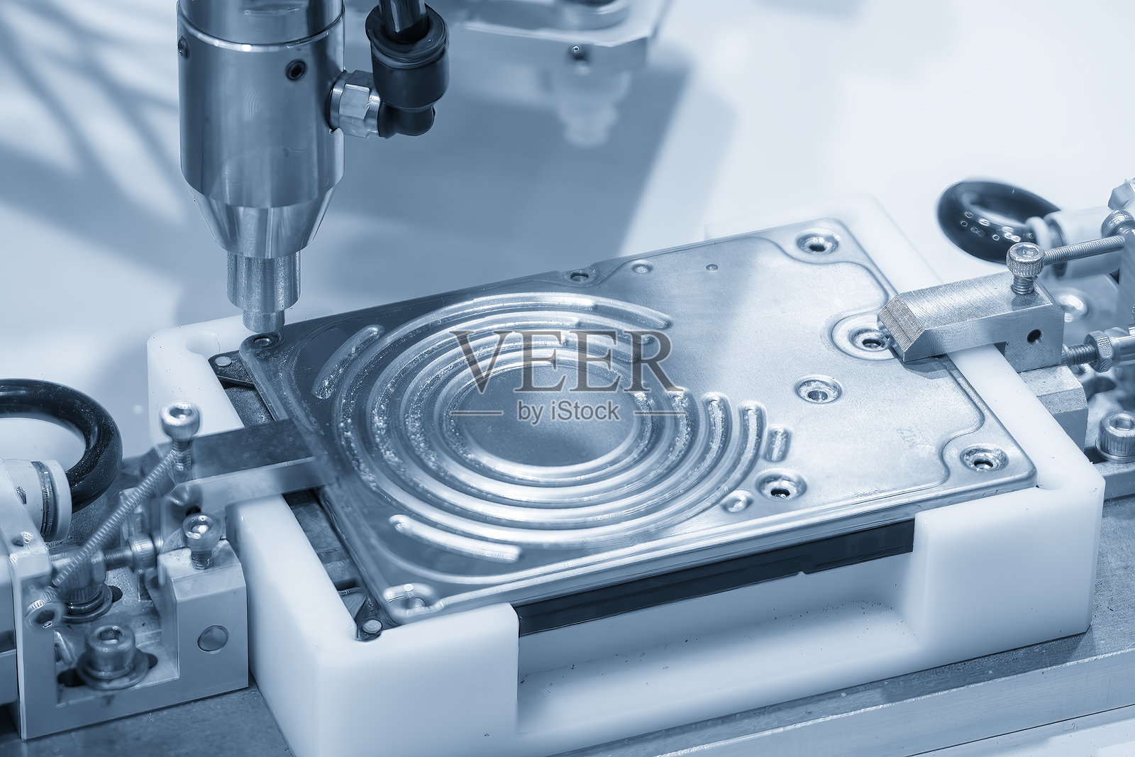 蓝色色调场景下,自动螺丝刀进行硬盘组装过程。照片摄影图片