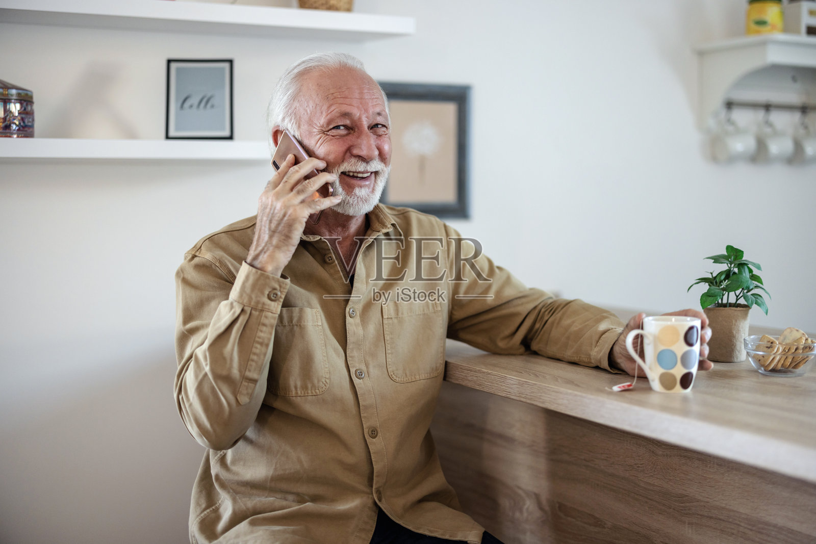 居家,电话和一位正在交谈、思考和讨论的老年男子。公寓,一位老年人和退休人员,使用手机,放松并与数字应用程序互动并微笑。照片摄影图片