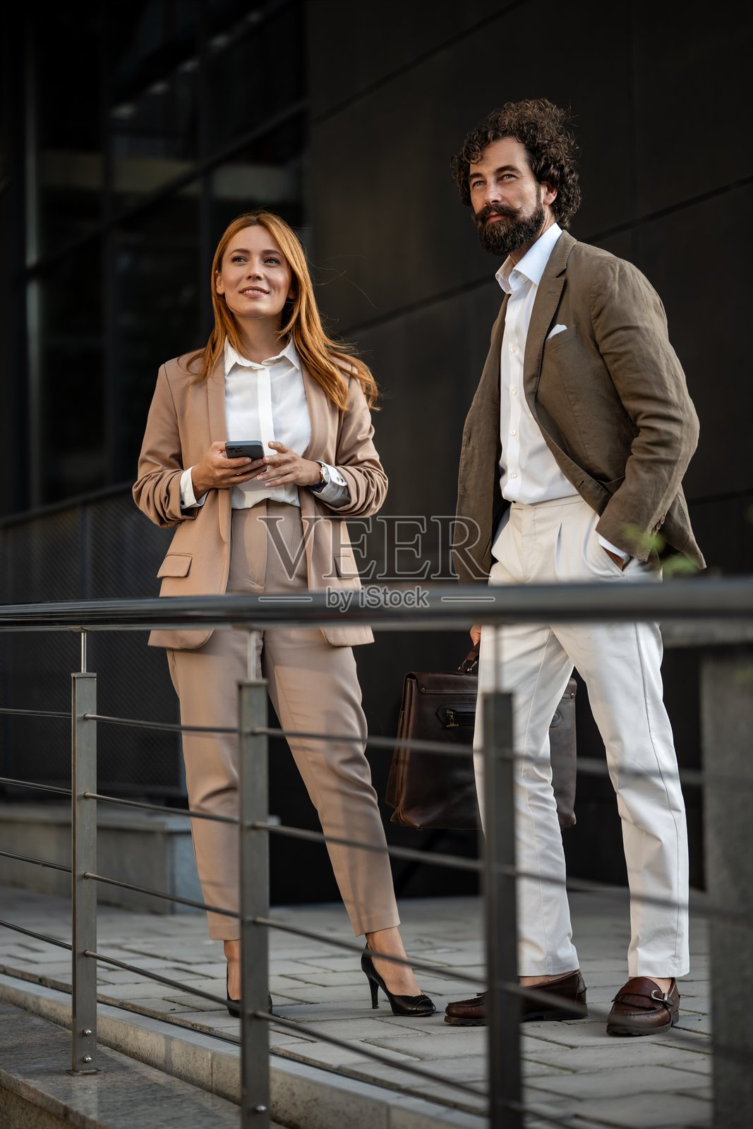 商务人士在办公楼外讨论项目照片摄影图片