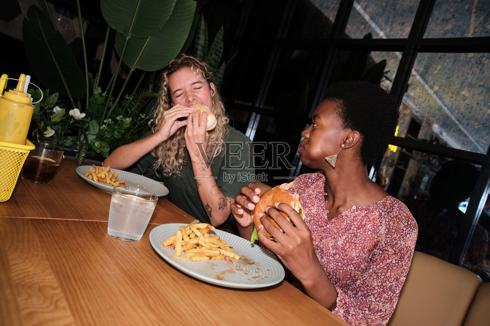 一群朋友在餐厅里吃汉堡和薯条照片摄影图片