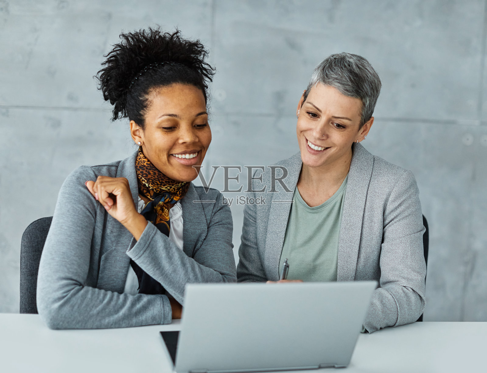 商务办公室女商人在笔记本电脑桌前与多元化的团队成员开会,体现了初创公司的团队合作、友谊、团结、多元化和社区精神。照片摄影图片