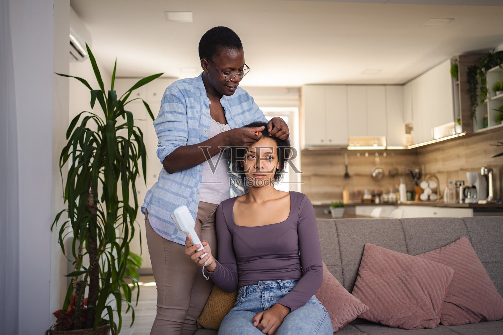 妈妈在家为青春期女儿打理头发照片摄影图片