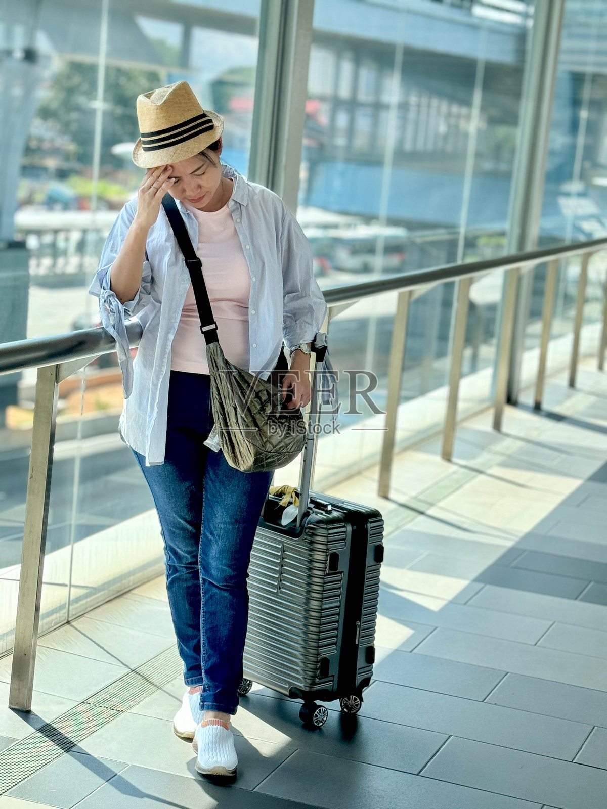 意料之外的延误:女子正在和朋友们发消息说明取消的行程照片摄影图片