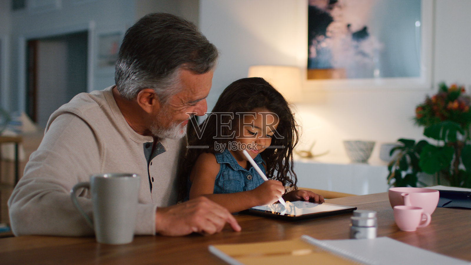 爷爷和孙女在家里的数码平板上绘画照片摄影图片
