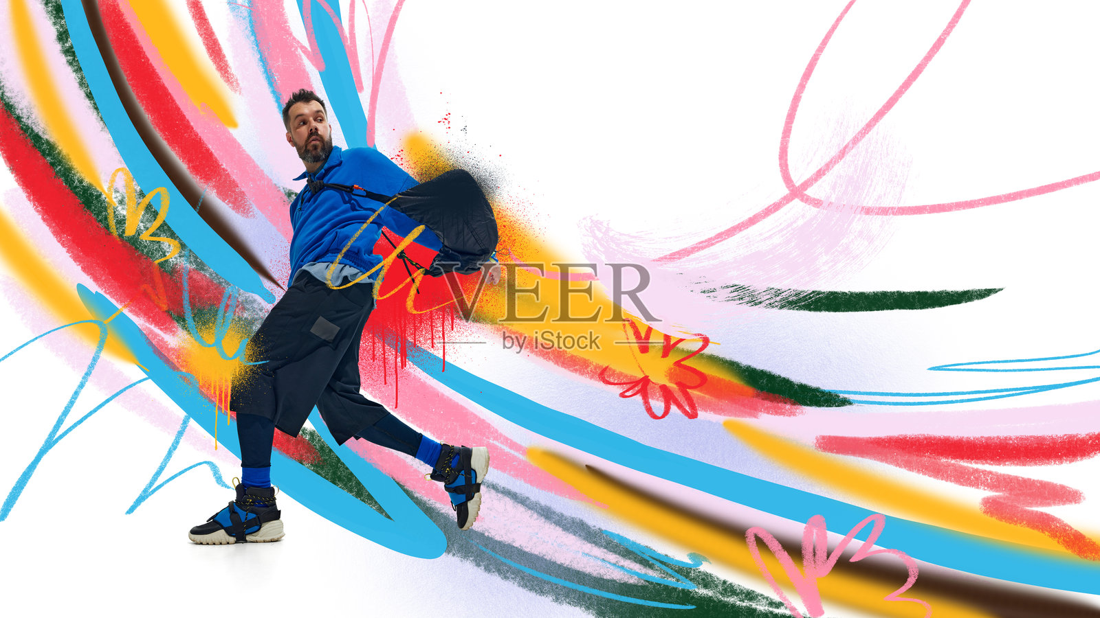 平面构图。身穿蓝色服装的男模特在充满活力的彩色涂鸦背景前摆姿势。照片摄影图片