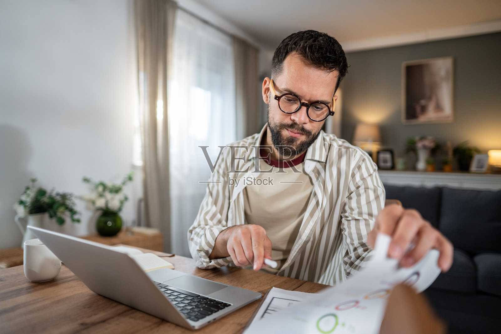 男人在家里的办公室审阅商业文件照片摄影图片
