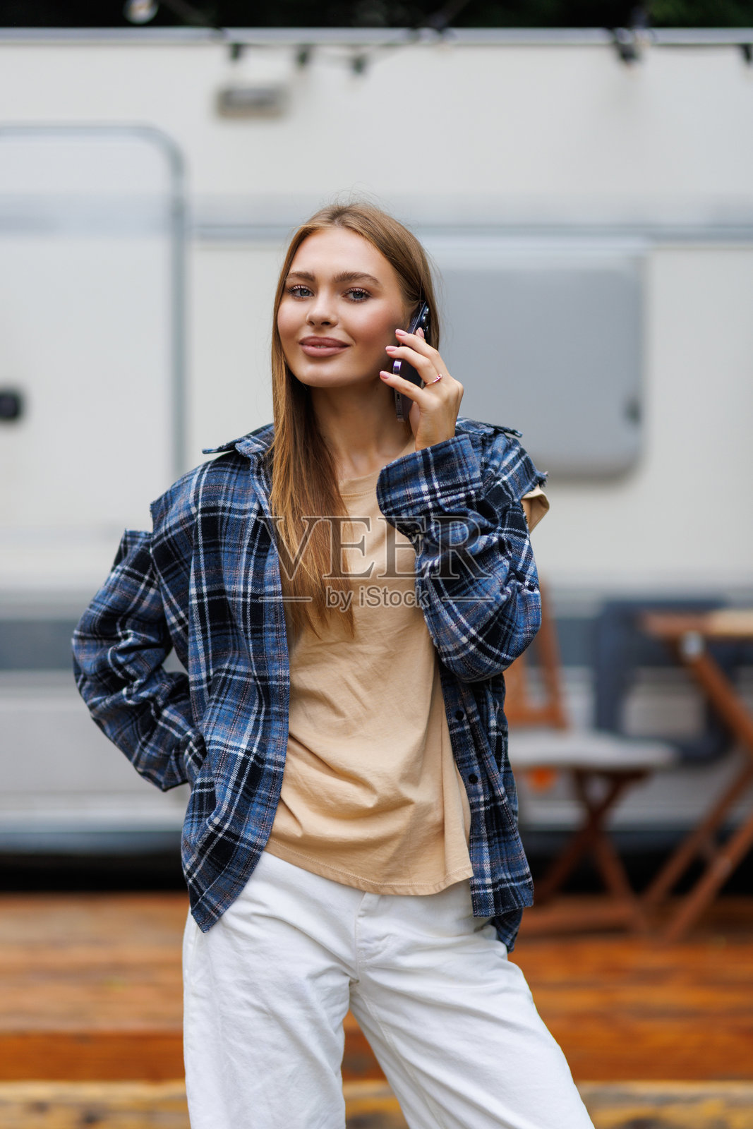 年轻女子站在房车前讲电话照片摄影图片