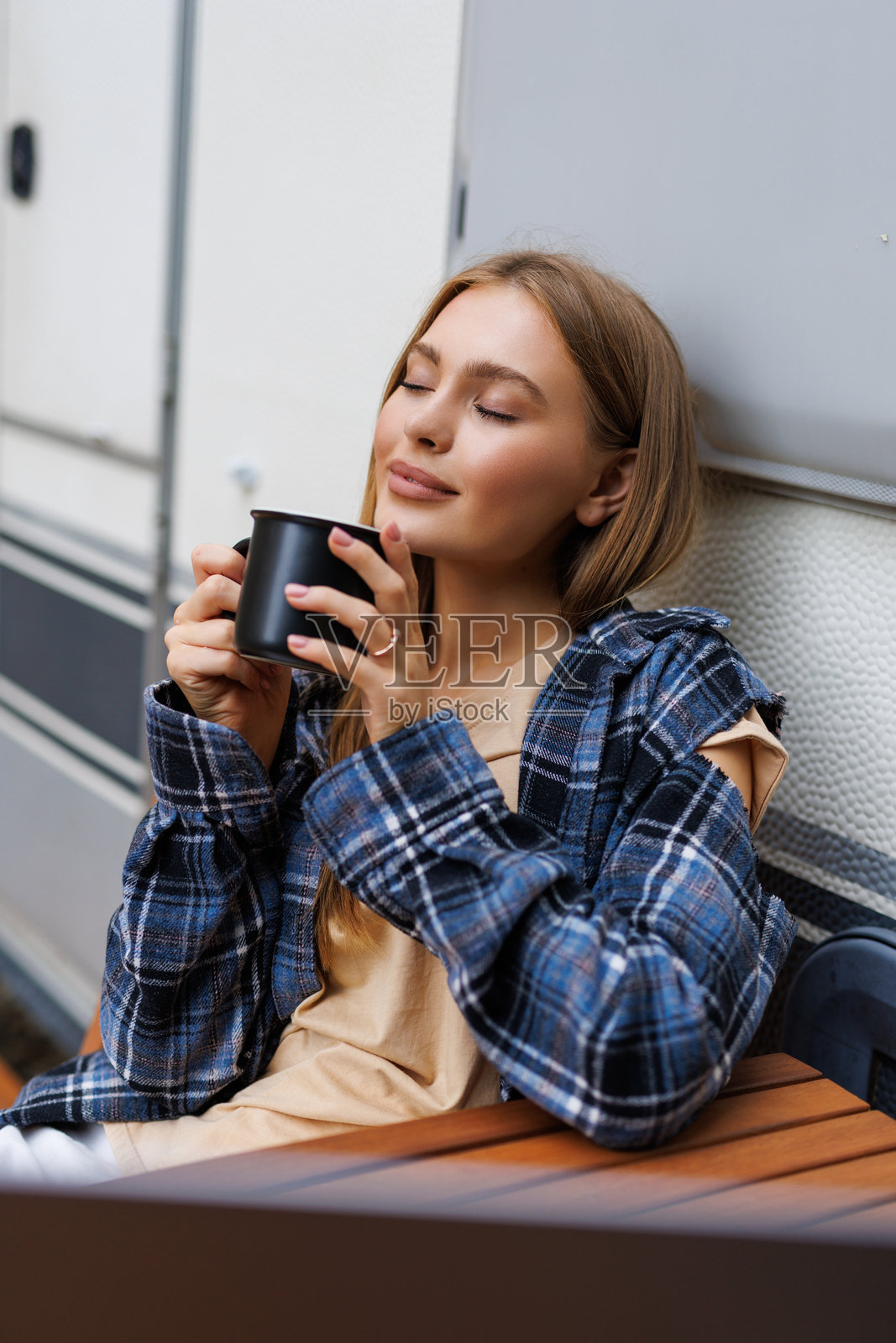 年轻女子在露营车房车的门边喝咖啡照片摄影图片