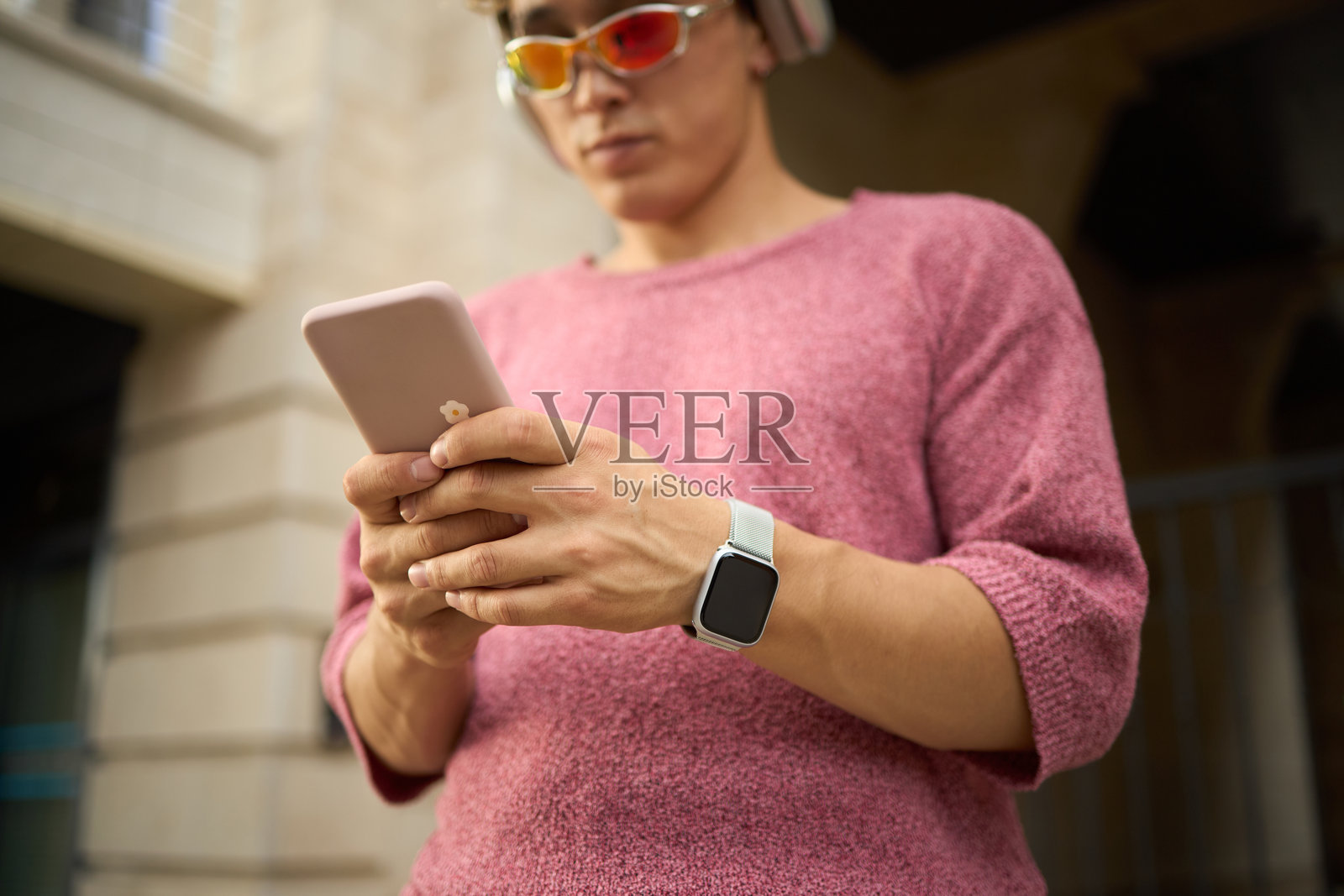 年轻白种男子在户外戴着耳机使用智能手机照片摄影图片