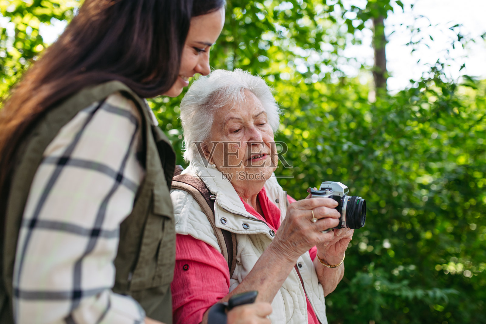 年长的母亲和女儿在森林散步时拍摄野生动物。照片摄影图片