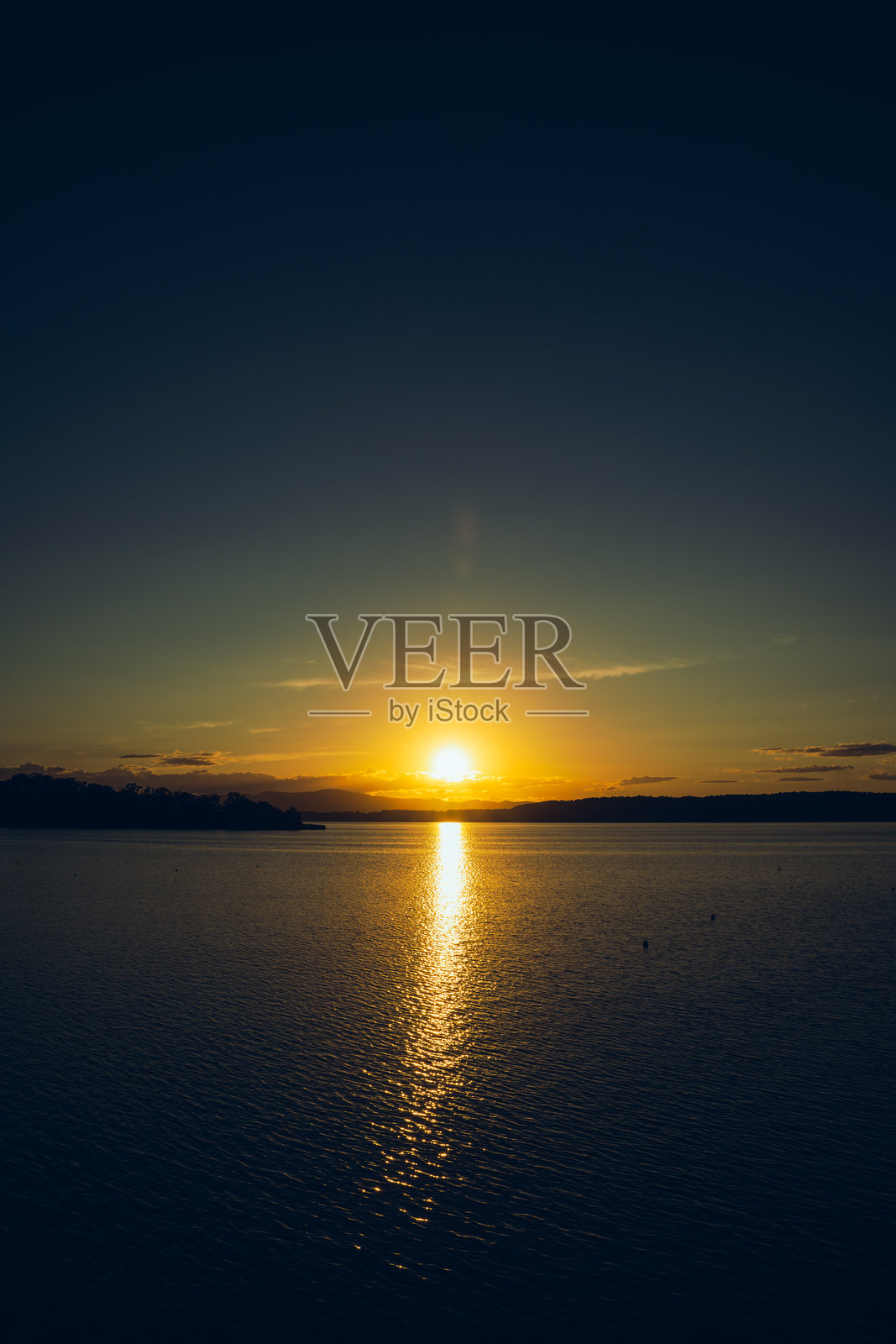 夕阳下的湖泊。照片摄影图片