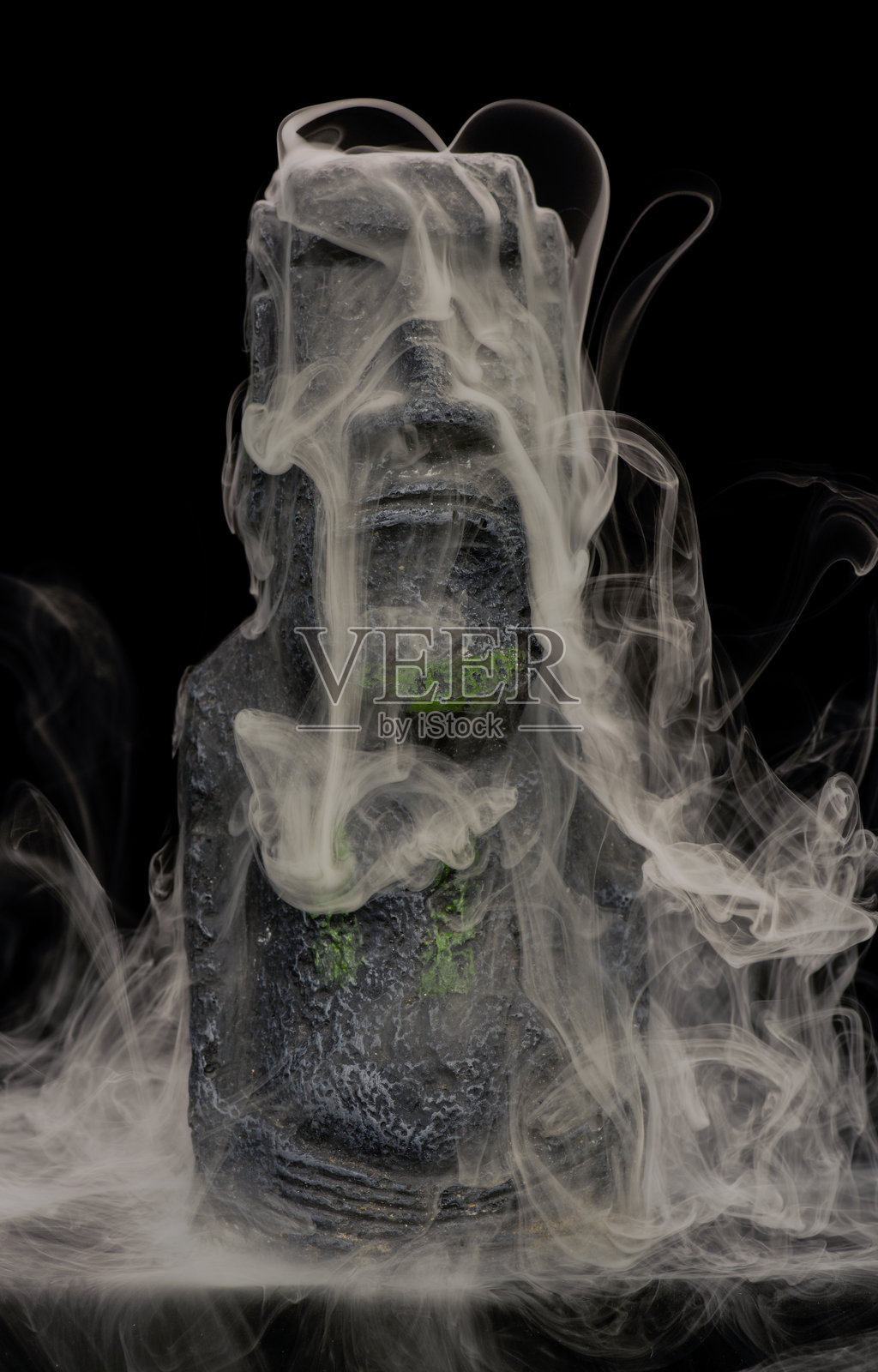 复活节岛石像静物,带有奇异的旋转烟雾和薄雾,由摄影师用硅胶模具和园林石手工制作。照片摄影图片