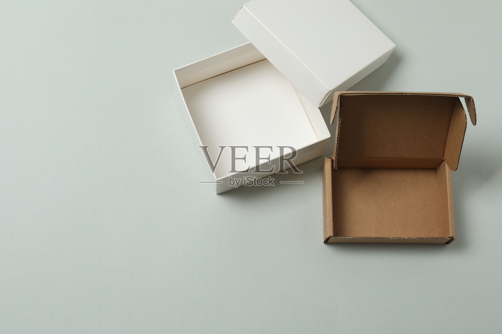 带盖的空纸盒放在灰色背景上,俯视照片摄影图片