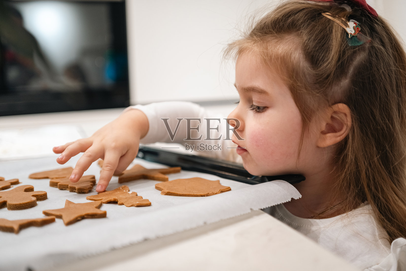 小女孩在家和家人一起开心地装饰节日姜饼,充满乐趣照片摄影图片