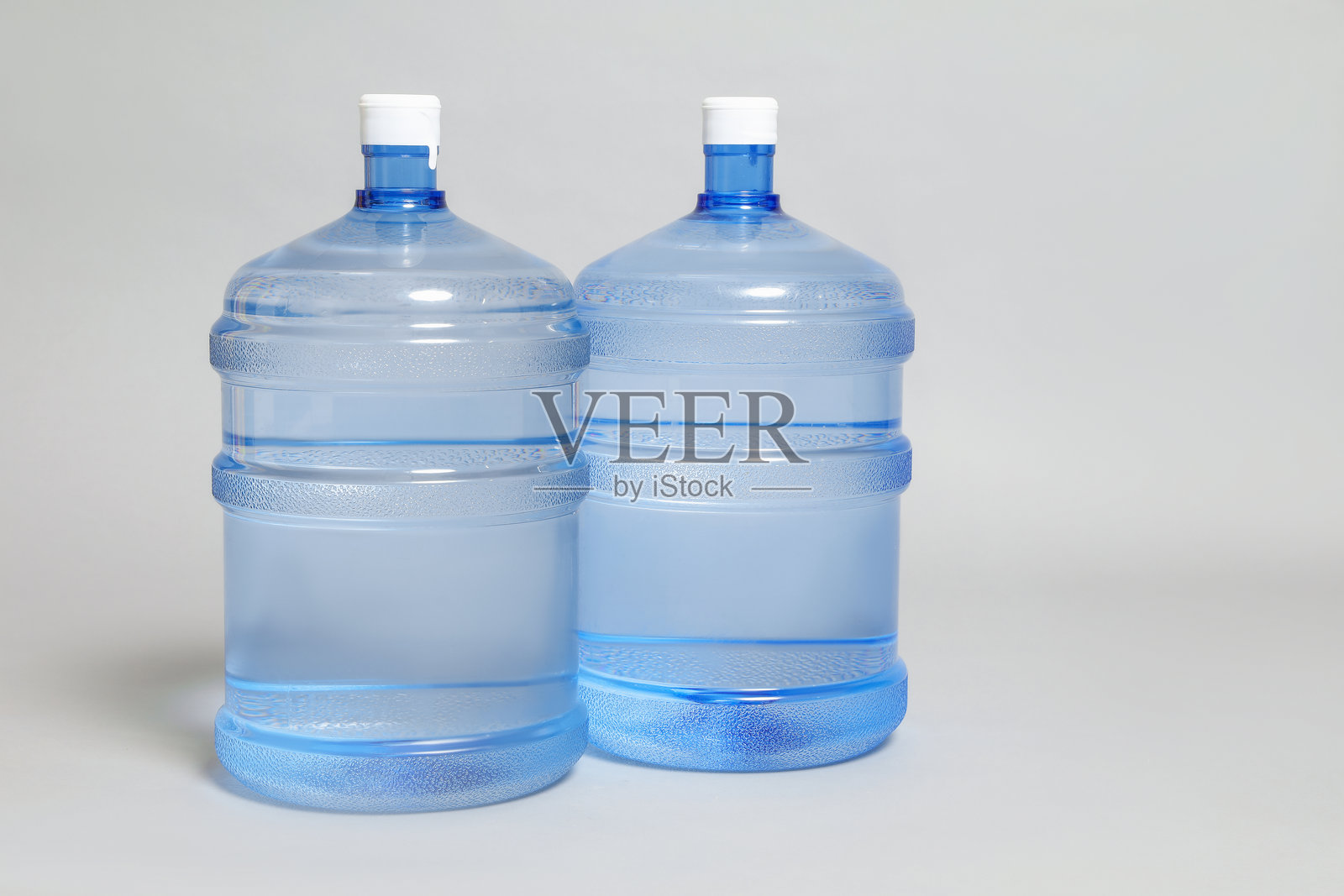 近距离拍摄的装有水的酷炫瓶子,背景为浅灰色。留有文字空间。照片摄影图片