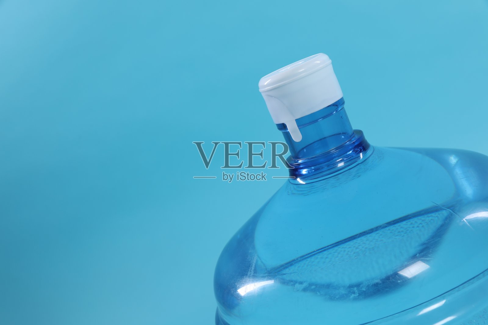 特写镜头下,带有水的蓝色冷却瓶,背景为浅蓝色。留有文字空间。照片摄影图片