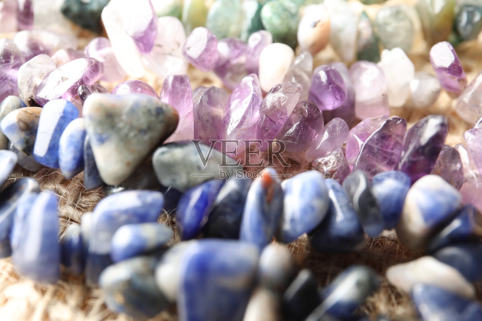 桌上摆放着许多不同的疗愈石,特写镜头。照片摄影图片