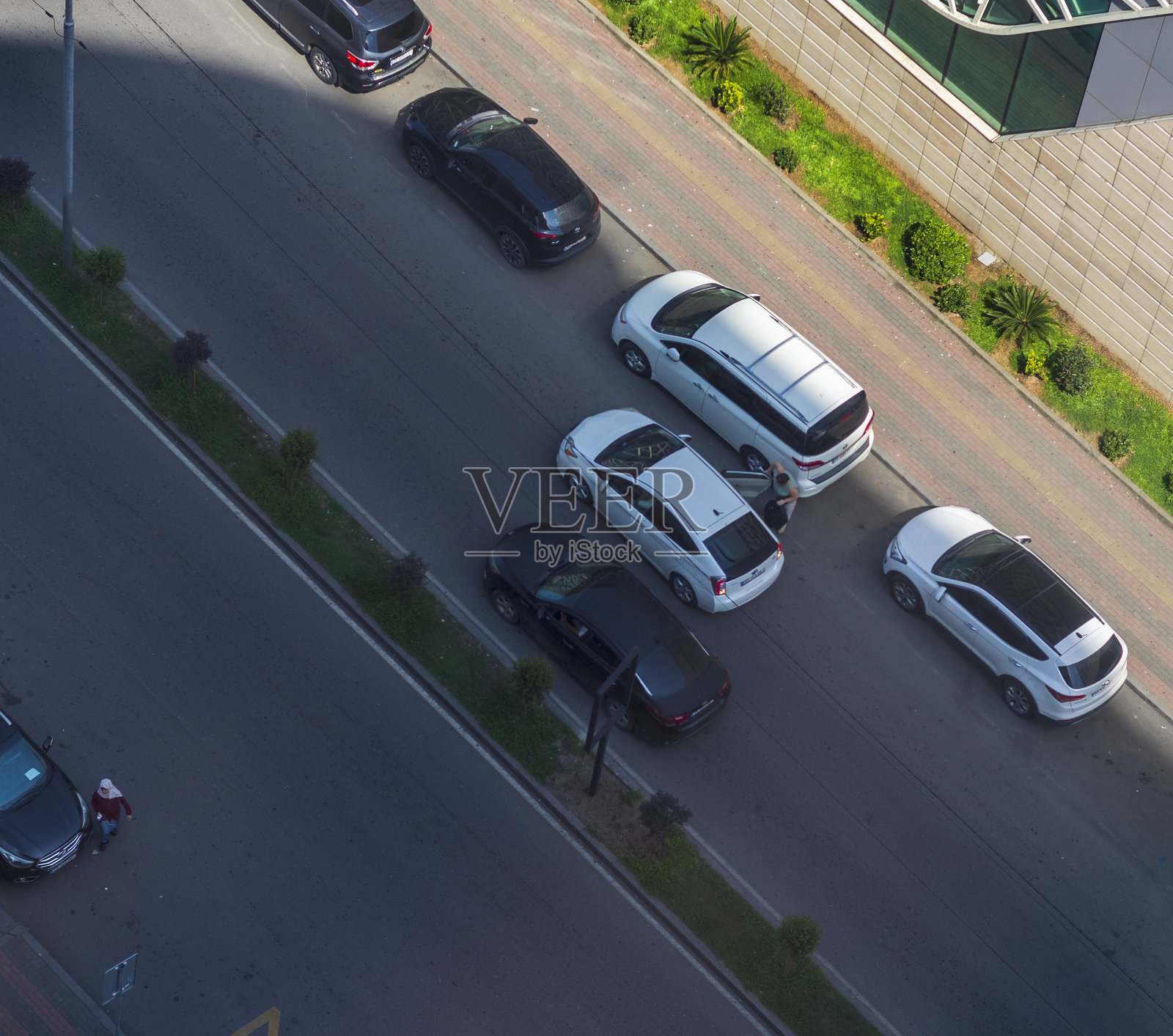 从上方拍摄的女子离开汽车的镜头。照片摄影图片