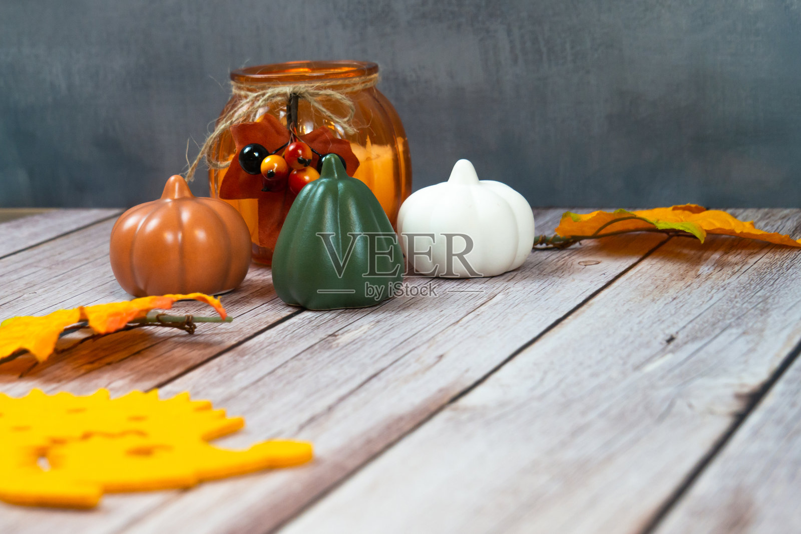 摆放着南瓜和落叶花瓶的桌子照片摄影图片