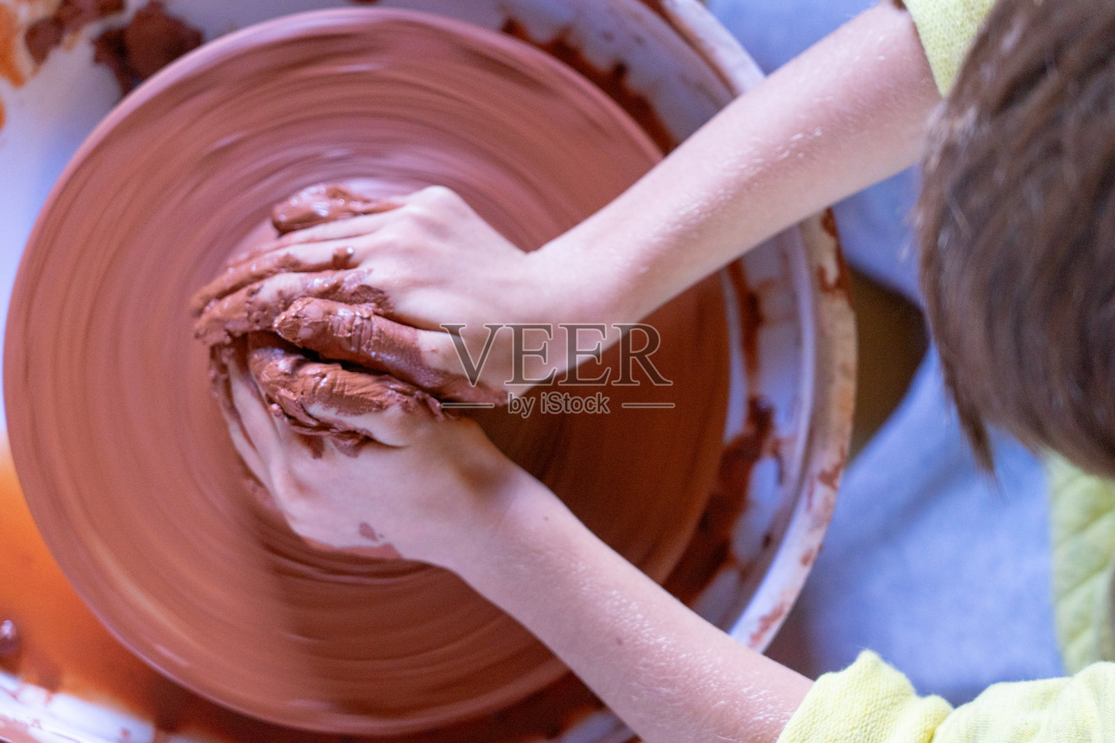 孩子在陶轮上制作陶艺品,创作艺术品照片摄影图片