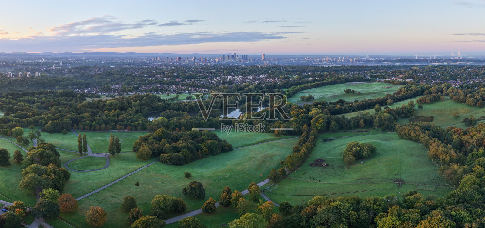 日出时的希顿公园,远处是曼彻斯特。照片摄影图片