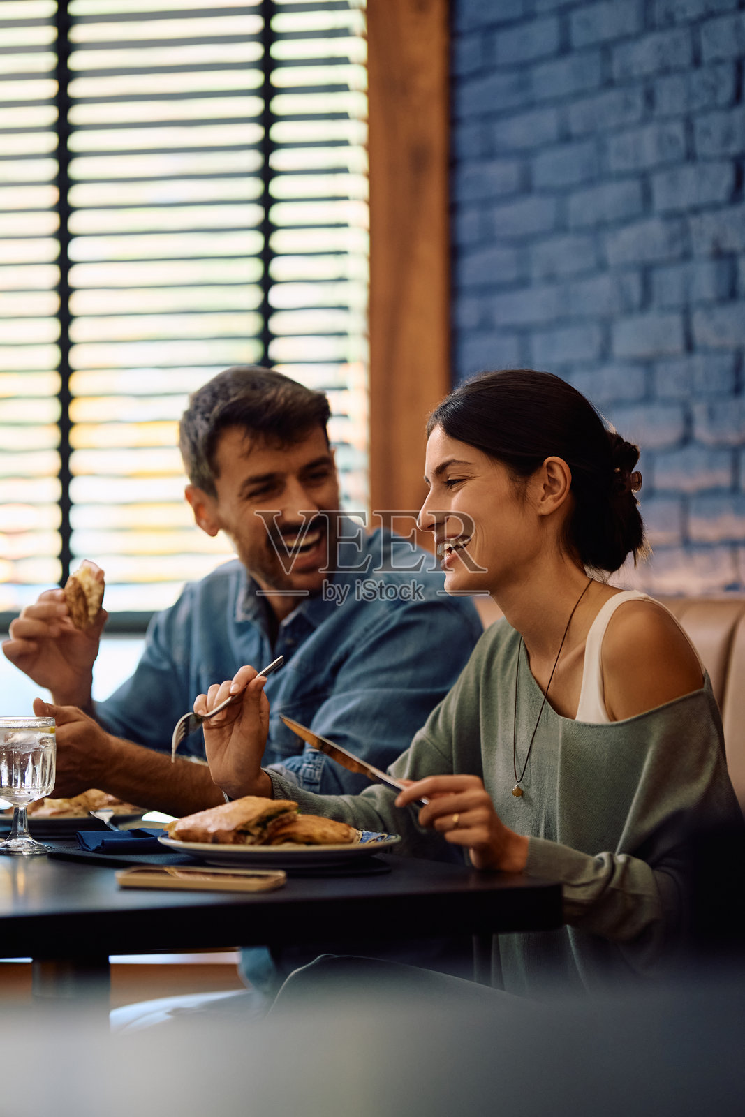 一对快乐的情侣在餐厅享用午餐。照片摄影图片