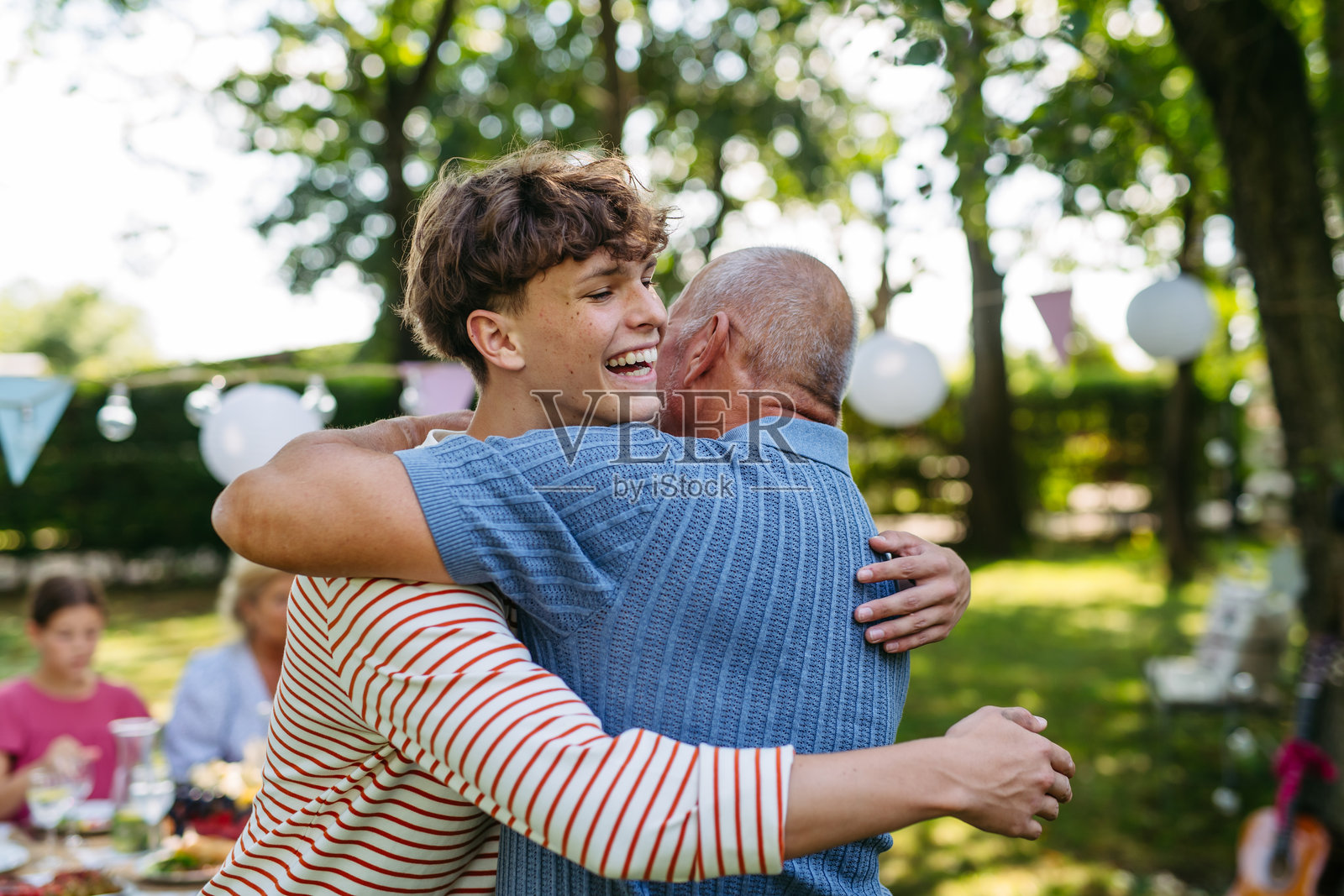 孙子拥抱爷爷向他问好。照片摄影图片