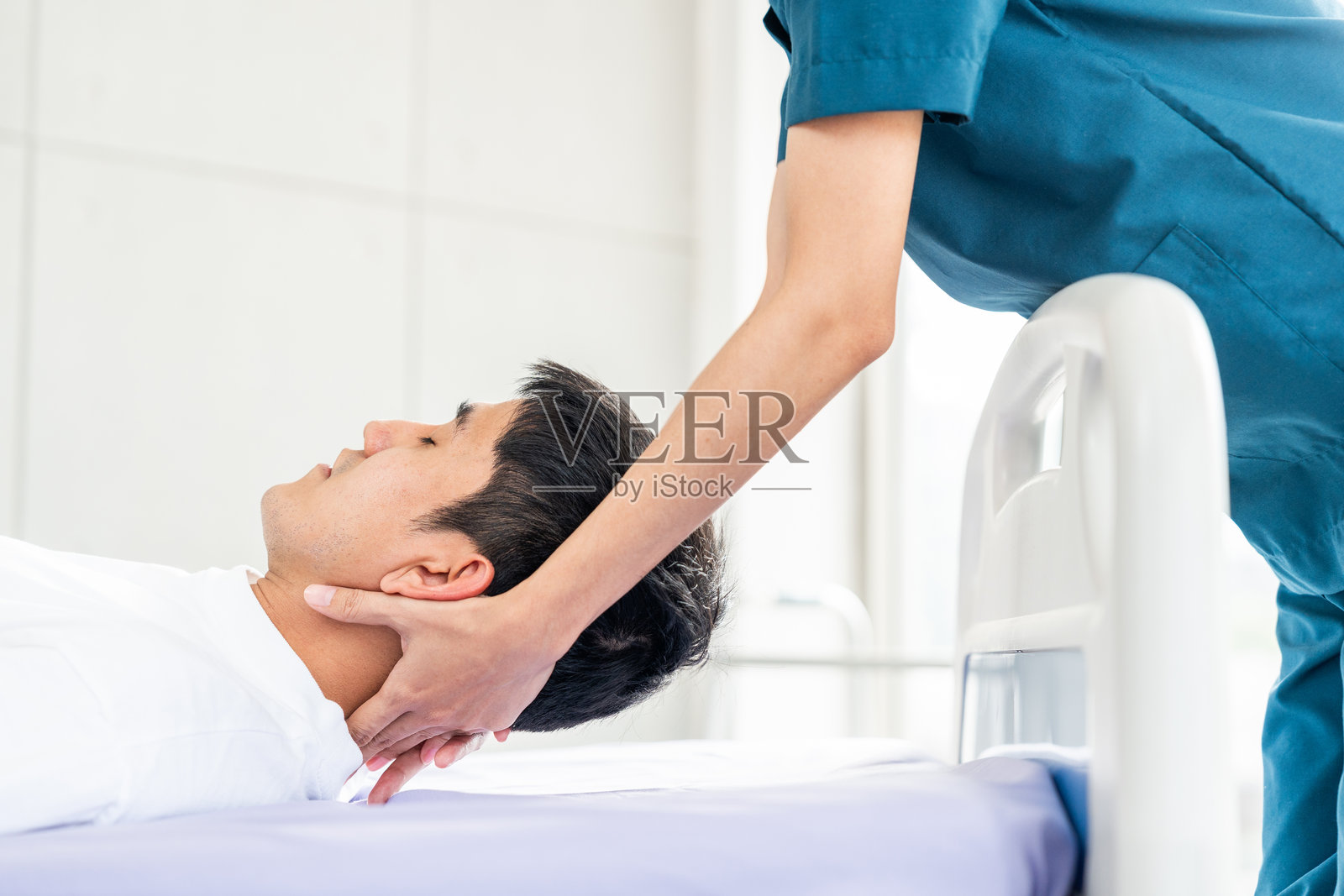 物理治疗。女护士协助一名年轻男子从脊柱损伤中恢复,并进行骨科按摩。骨科保健和脊椎按摩师为物理治疗康复进行治疗。照片摄影图片