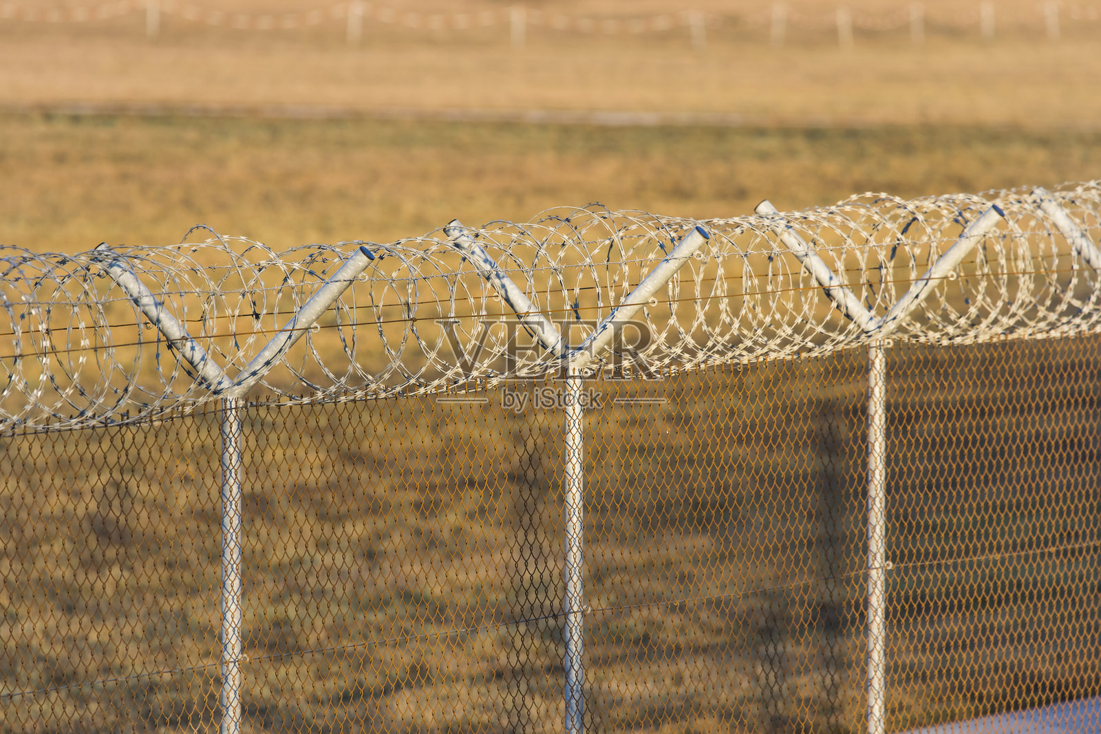 国际边境带刺铁丝网的栅栏照片摄影图片