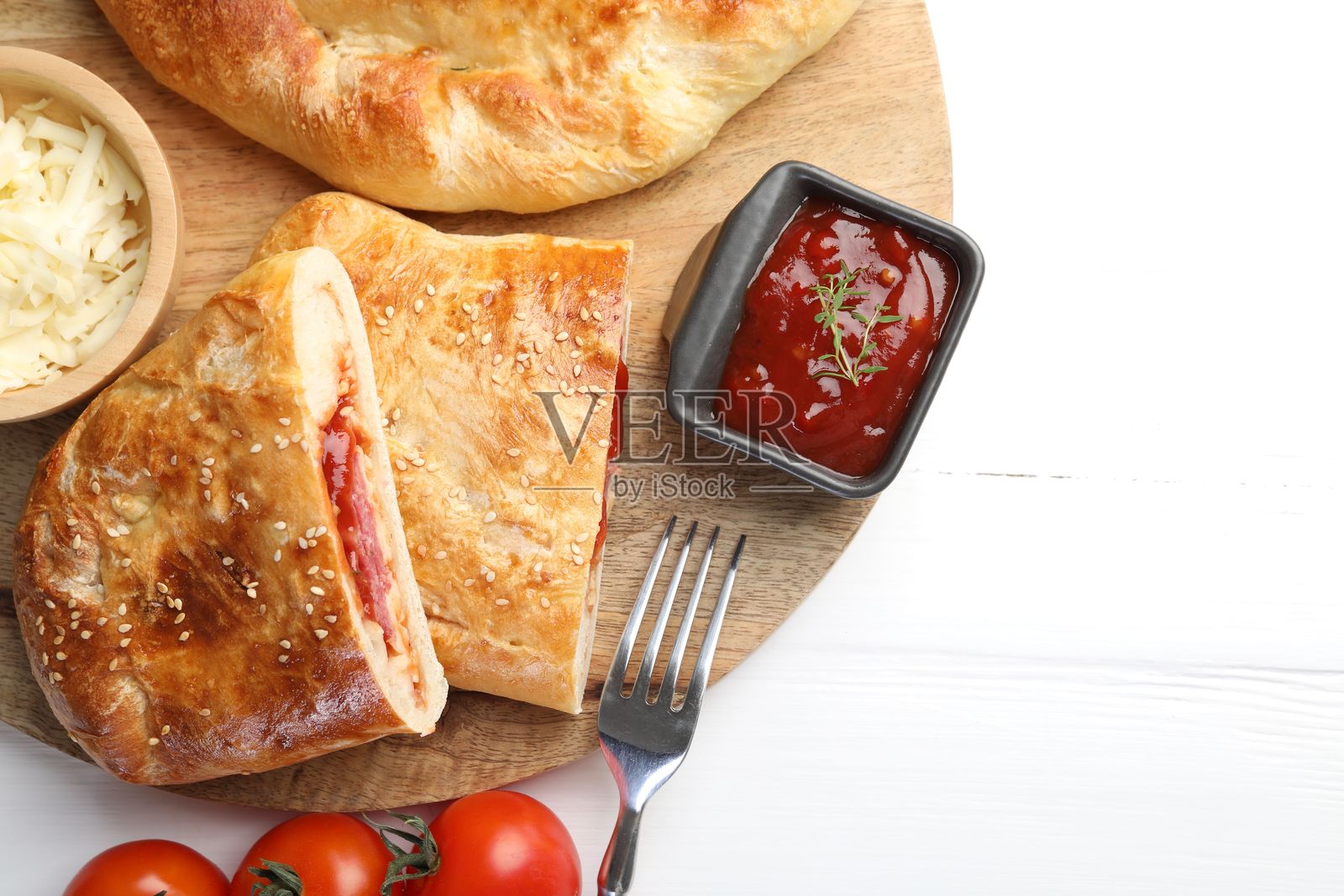 新鲜的卡尔佐内披萨块,在白色的木桌上,俯视角度照片摄影图片