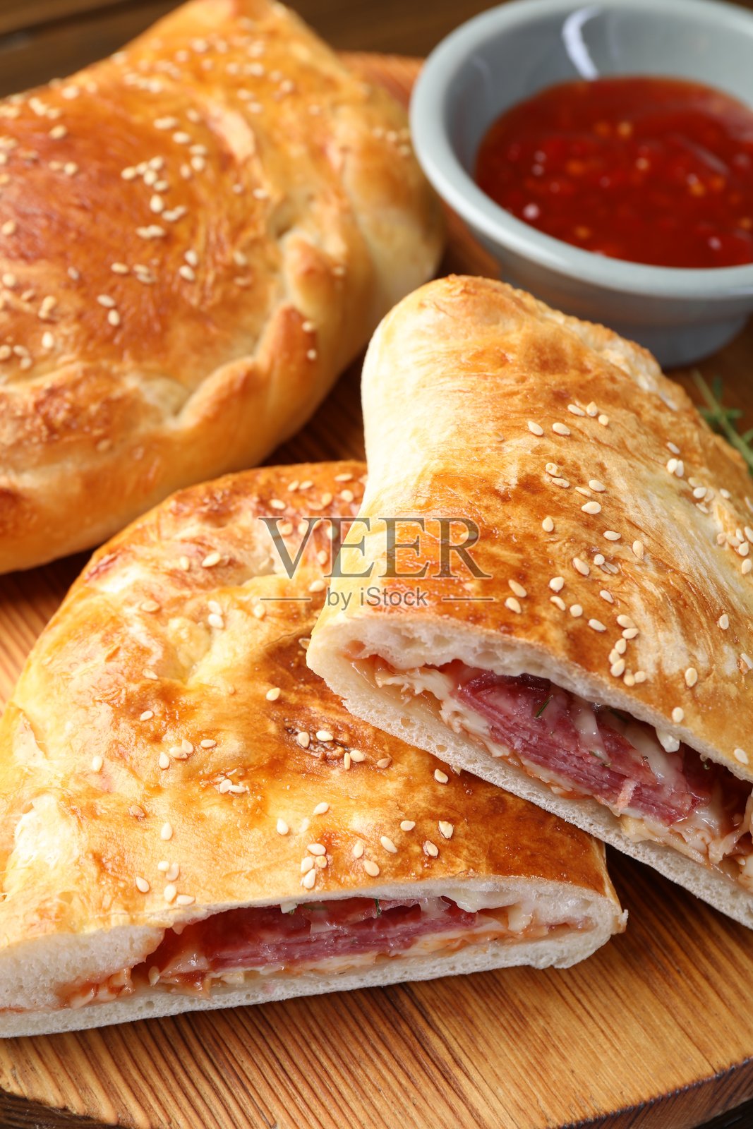 木桌上的卡尔佐内披萨特写照片摄影图片