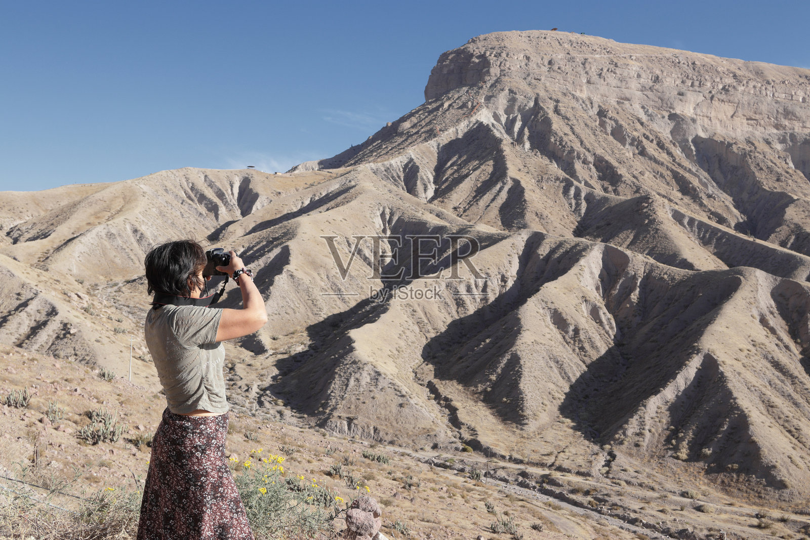 女探险家正在拍摄干旱的山区沙漠景观照片摄影图片