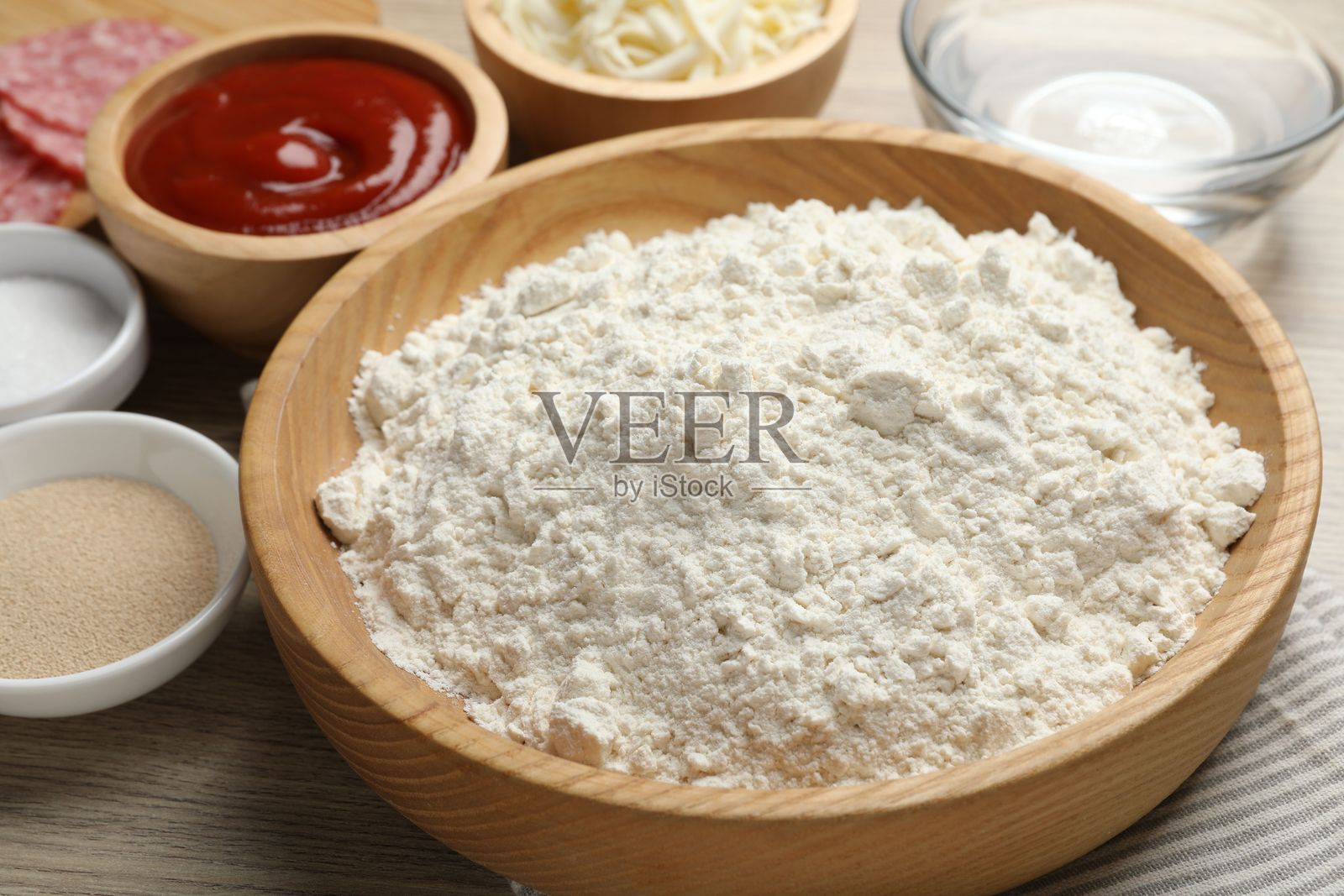 制作卡尔佐内披萨。木桌上的不同食材,特写照片摄影图片