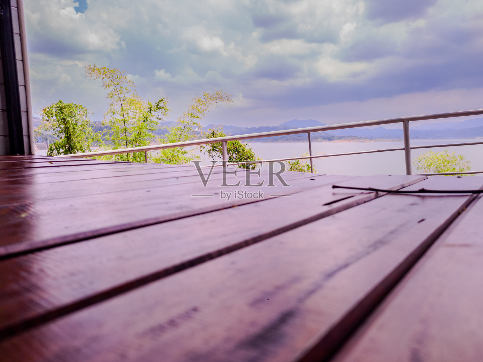 从木制露台望向阴天下的宁静湖景照片摄影图片