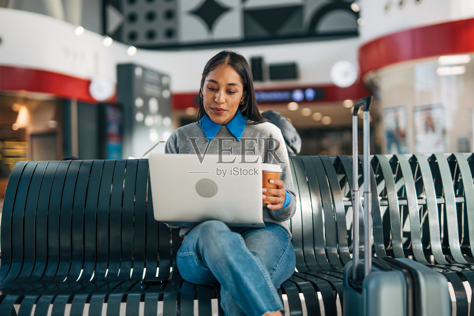 女子在机场候机时使用笔记本电脑工作照片摄影图片