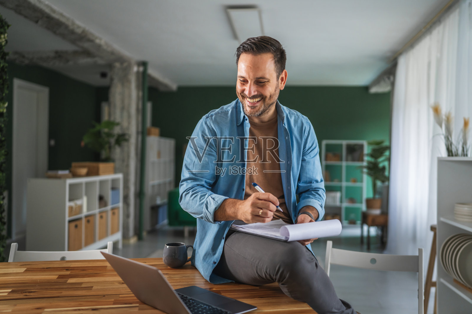 面带微笑的男士在家办公,规划商业创意照片摄影图片
