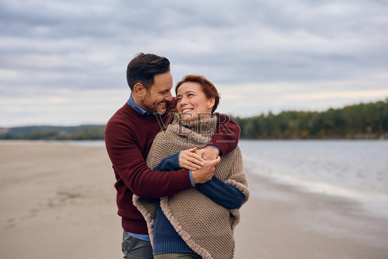 秋日户外,恩爱夫妻深情相拥。照片摄影图片