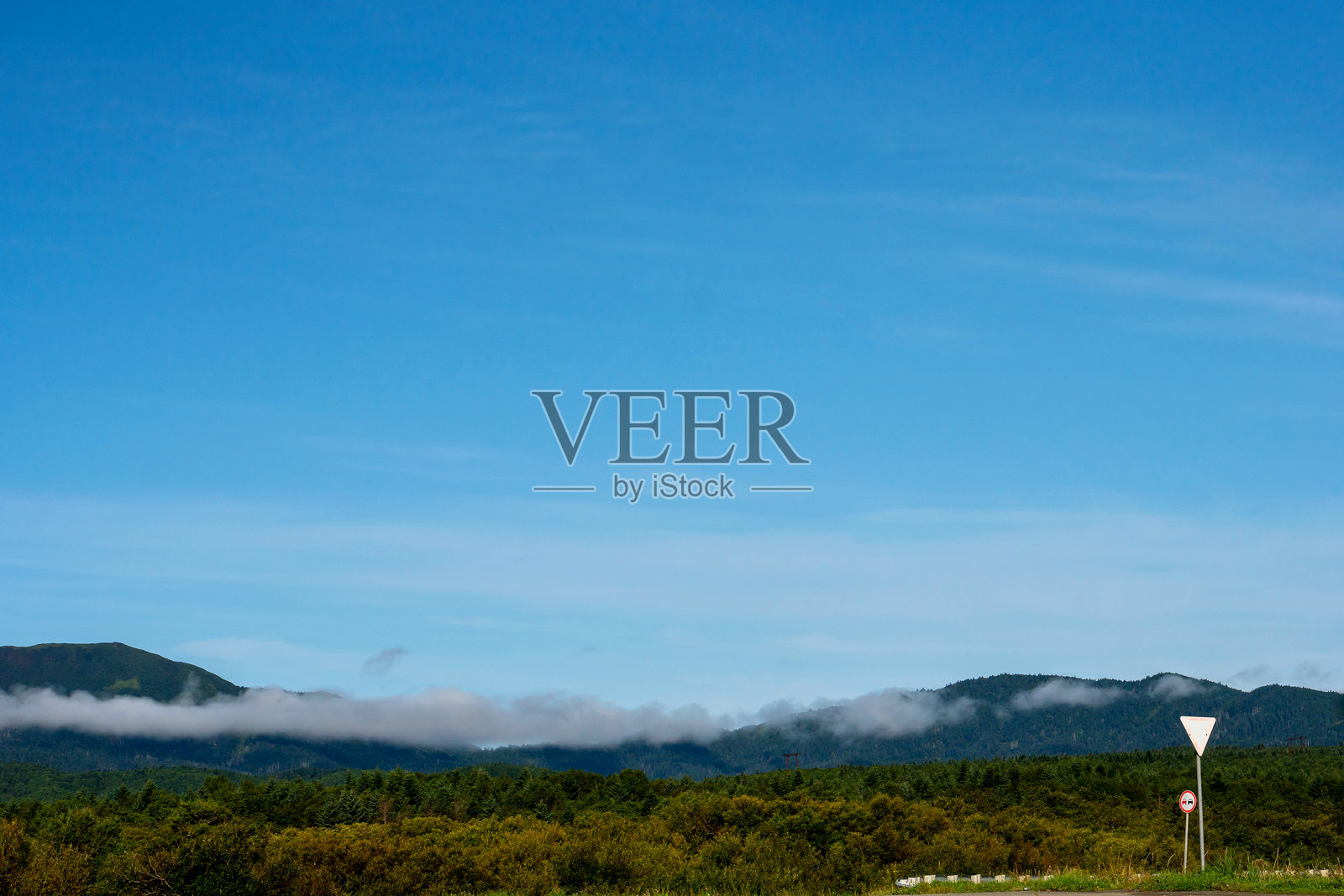 前景中有路边标志的薄雾山脉照片摄影图片