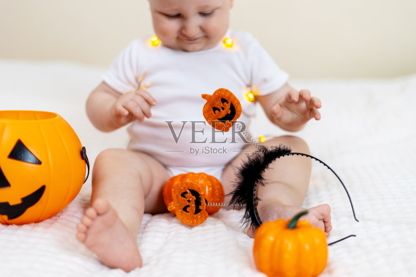 宝贝在床上玩万圣节装饰品照片摄影图片