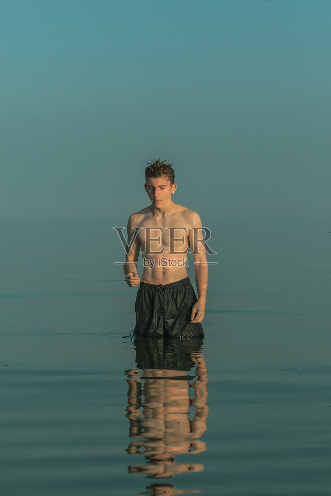 一名少年站在海里照片摄影图片